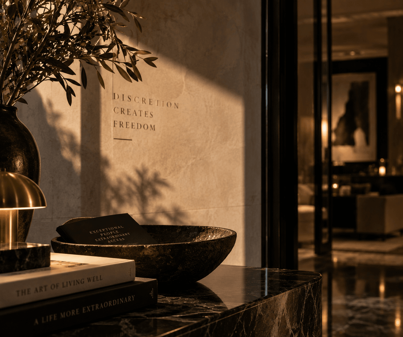 Sunlight across a plaster wall and a stone bowl on a dark console